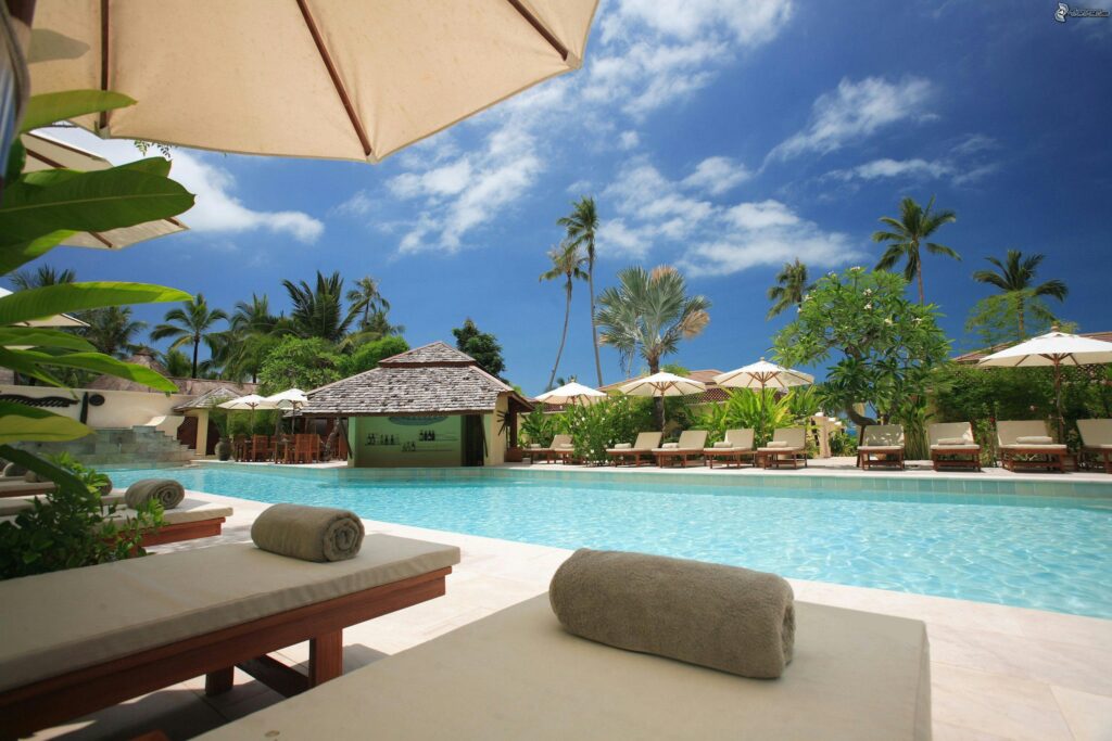Resort spa tropical avec chaises longues, bassins et espace de relaxation en bord de piscine